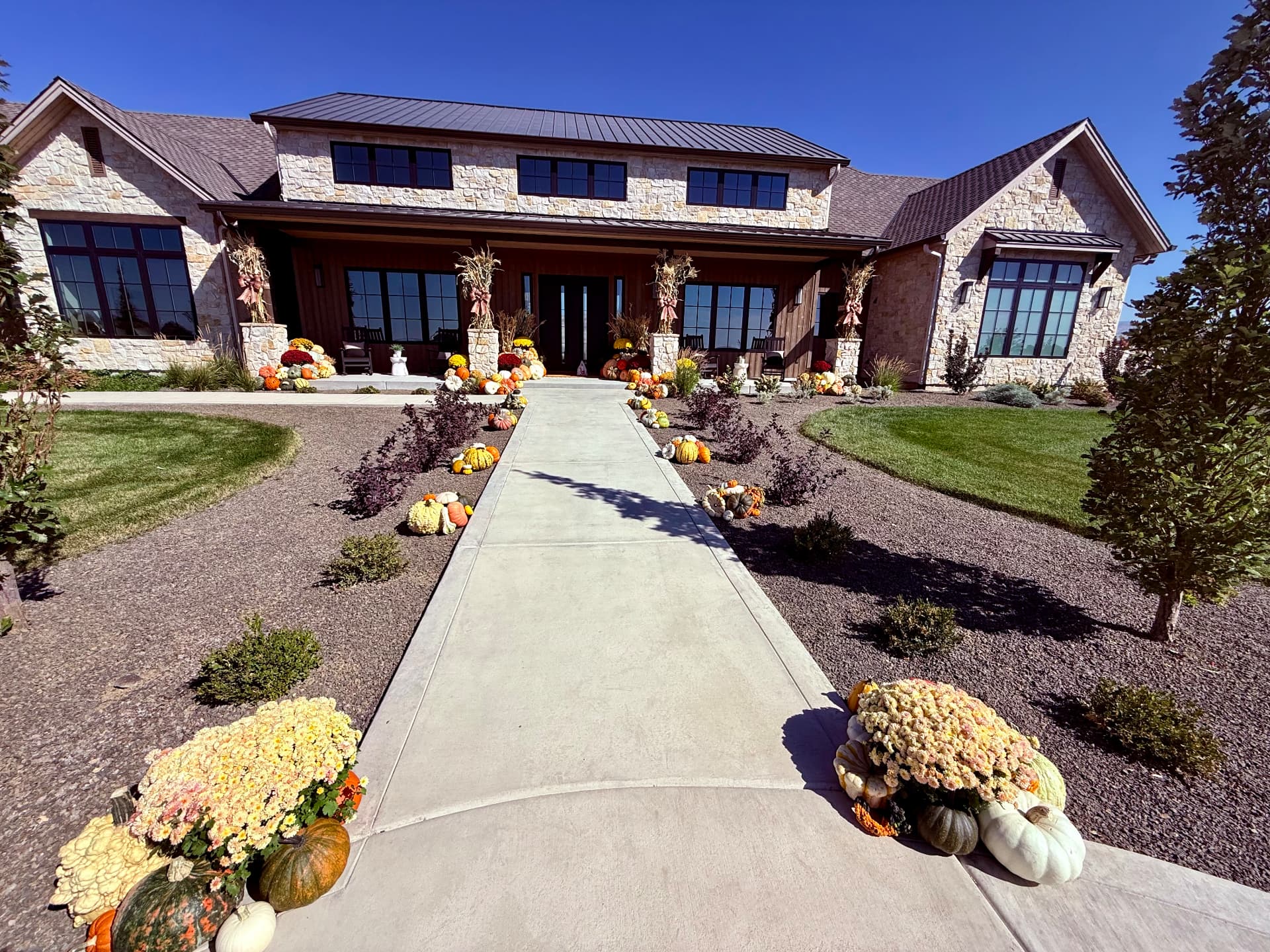 Luxury Idaho home entrance with a professionally designed heirloom pumpkin installation on the stone steps